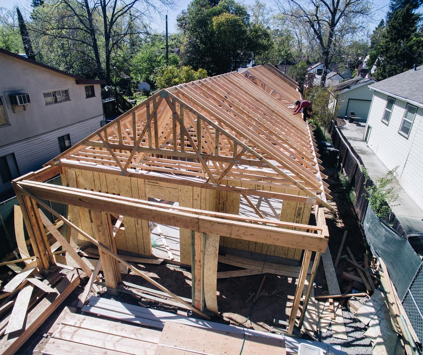 Roof trusses set over a newly framed structure, seen from above.