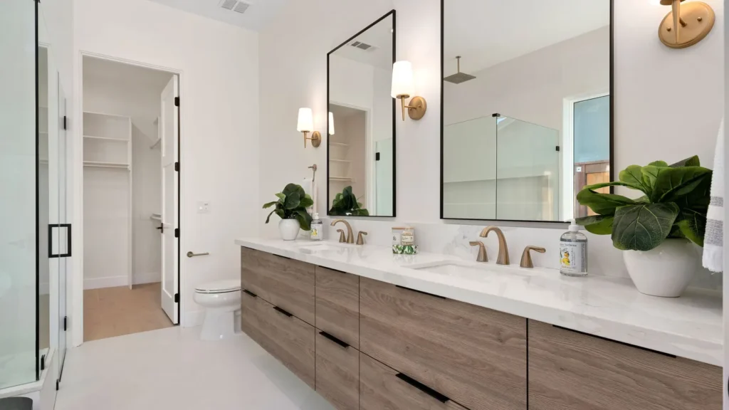 The primary bathroom, a double vanity in oak beneath twin mirrors.