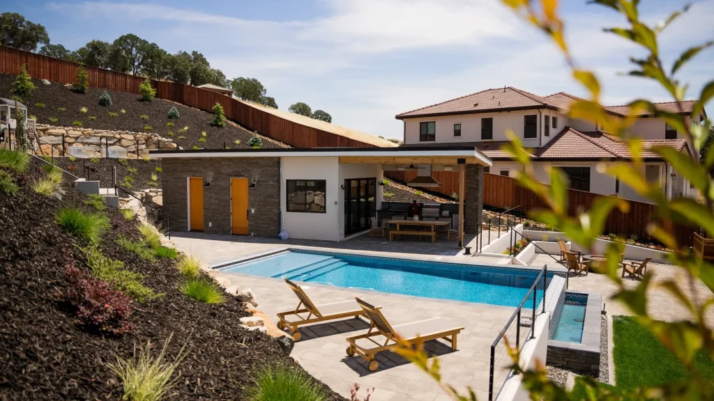 The pool house and pool seen across planting from the upper garden.