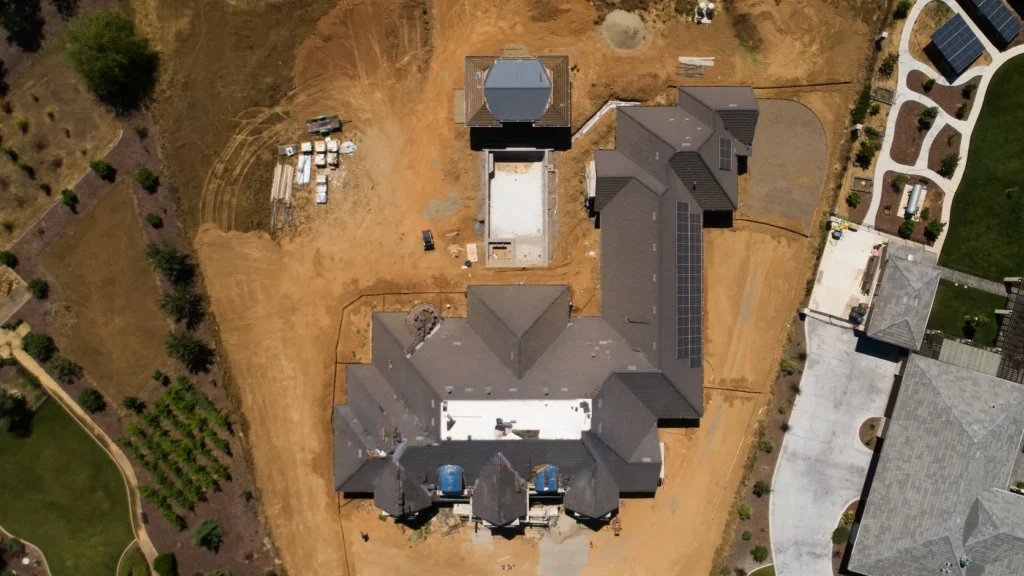 The whole site from directly above, drive and pool laid out.